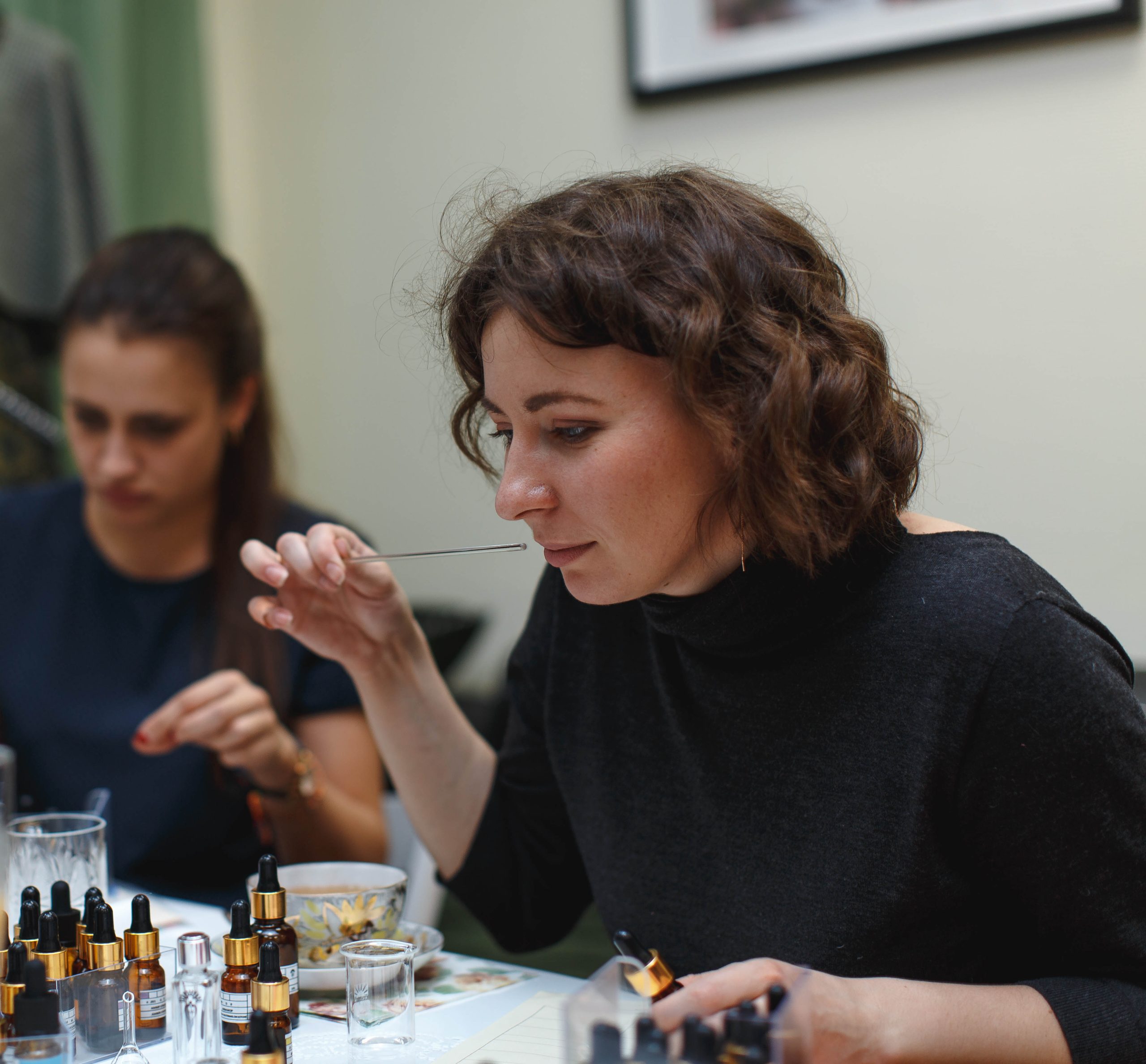 Partecipante valuta una materia prima con una mouillette durante il Perfume Workshop